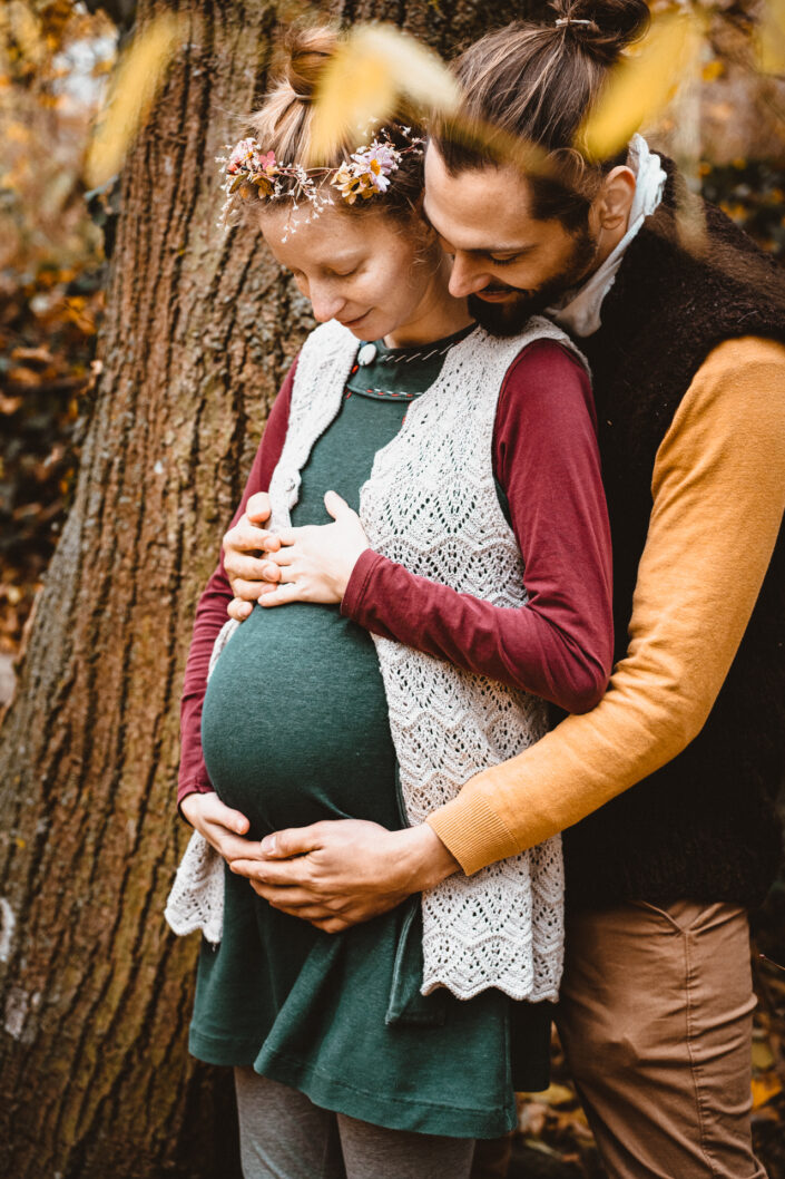 Herbstbilder mit Babybauch Mann und Frau bei Baum - dokumentarische Familienfotografie