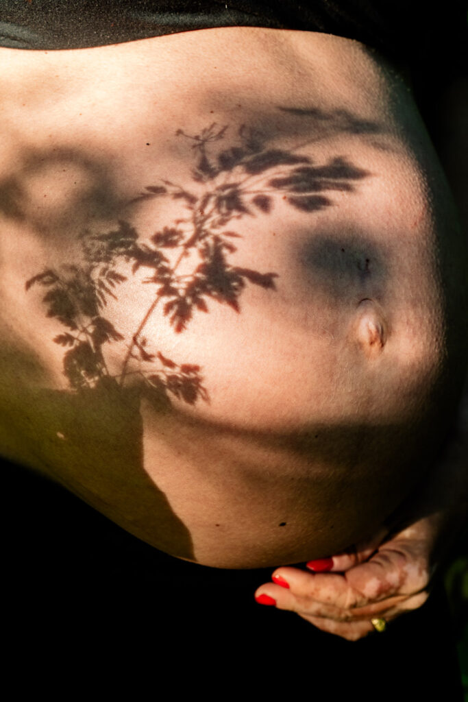 Babybauch mit Schatten auf nackter Haut - natürlich und emotional in der Natur