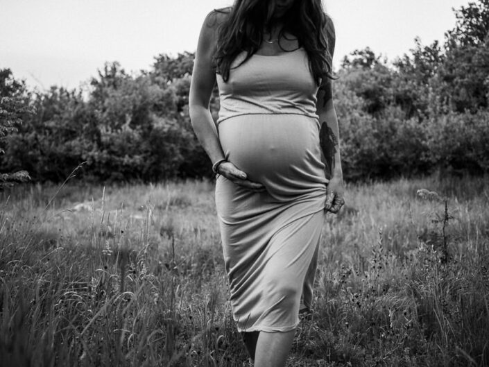 Werdende Mutter bei Sonnenaufgang barfuß in der Heide – natürliches Babybauchshooting im Wald