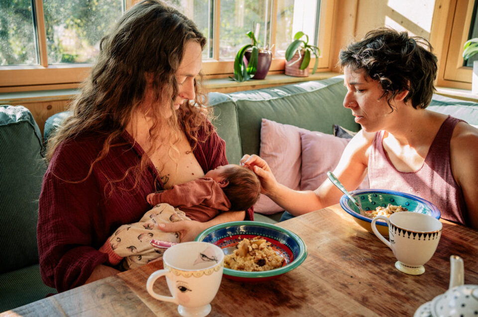 Zwei Mütter mit Baby beim gemeinsamen Essen im Wochenbett dank Doulabegleitung