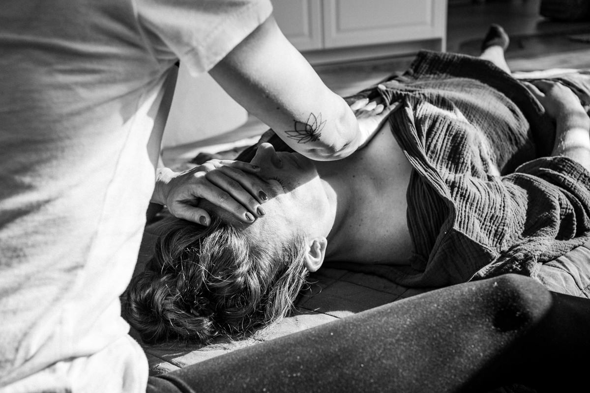 Doula umsorgt die Familie mit Massage und Zuwendung