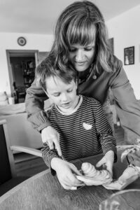 Mutter bäckt mit Kind bei Familienfotoshooting zuhause