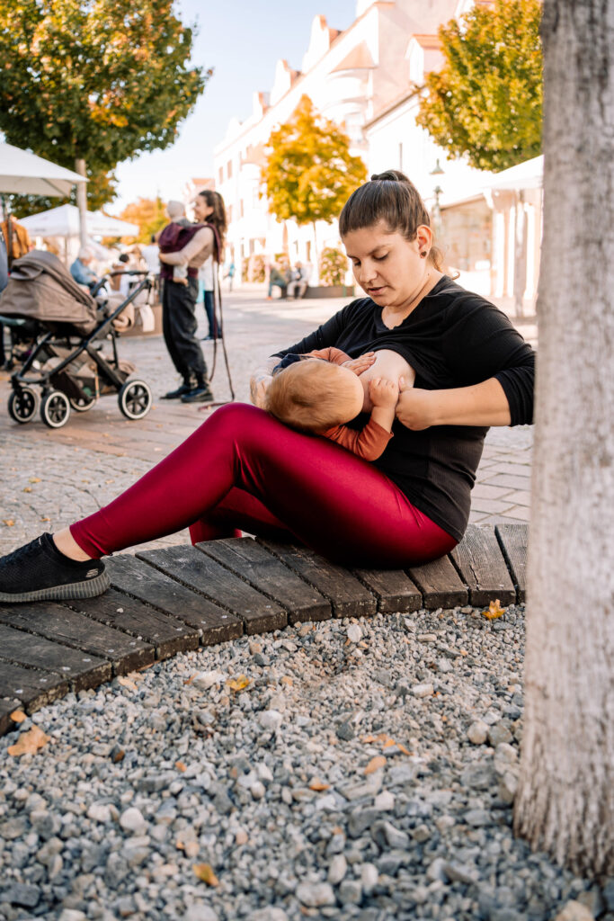 Stillende Mama auf Bank im öffentlichen Raum Fußgängerzone